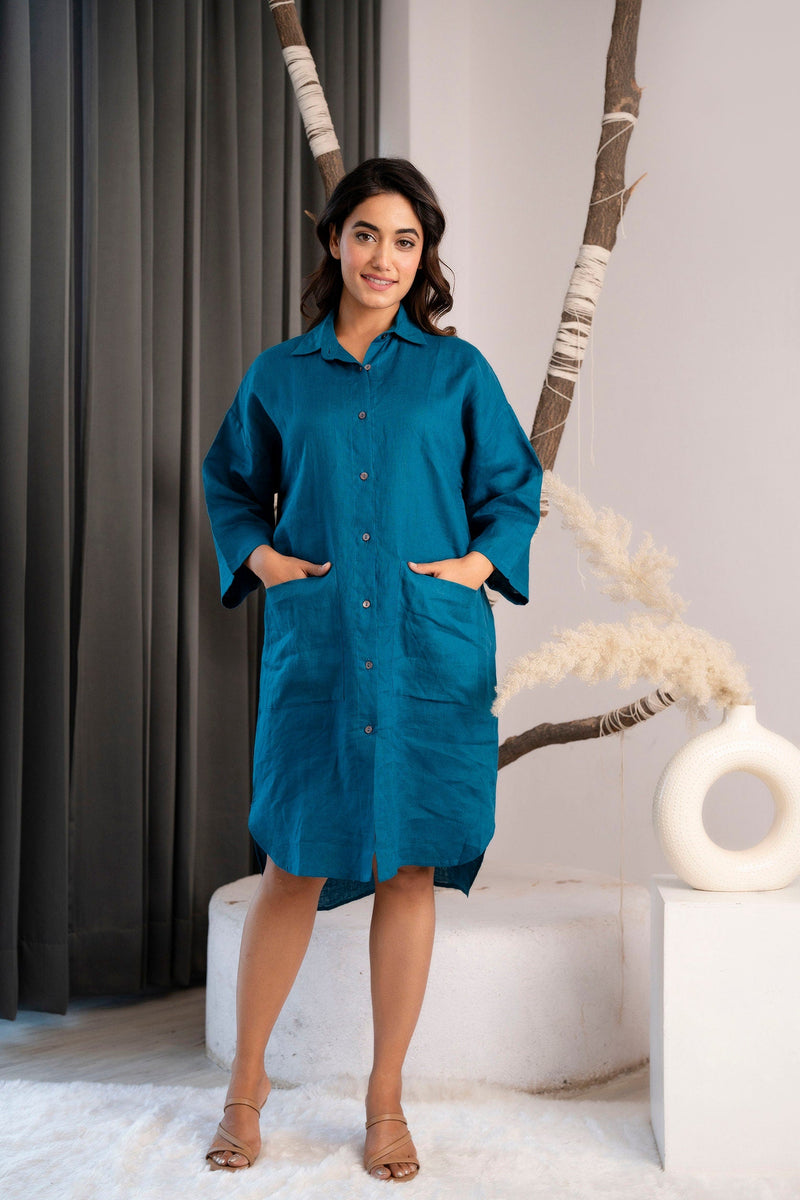 Woman in a Peacock Blue linen tunic with patch pockets and long sleeves