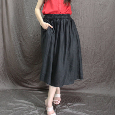 Black Linen Midi Skirt, Pleated Flared: Black midi skirt, hand in pocket, side angle