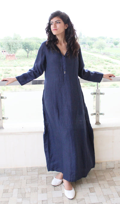 Blue Linen Maxi Dress with Hood: woman in Navy Blue linen maxi dress, arms resting on a railing, front view
