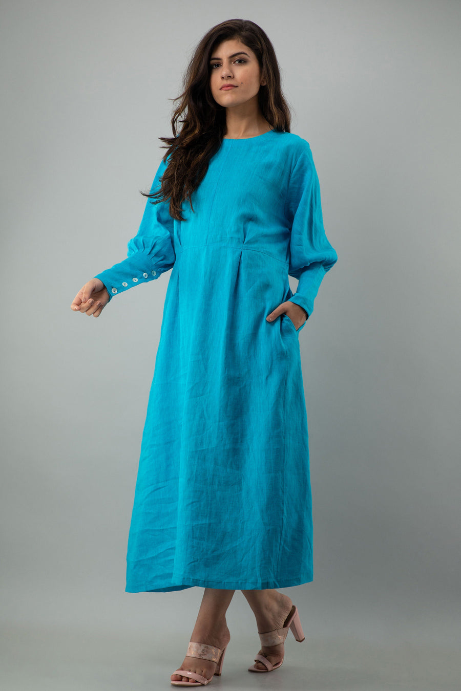 Blue Long Sleeve Linen Midi Dress: side angle of Turquoise Blue linen midi dress with buttoned cuffs, arm out