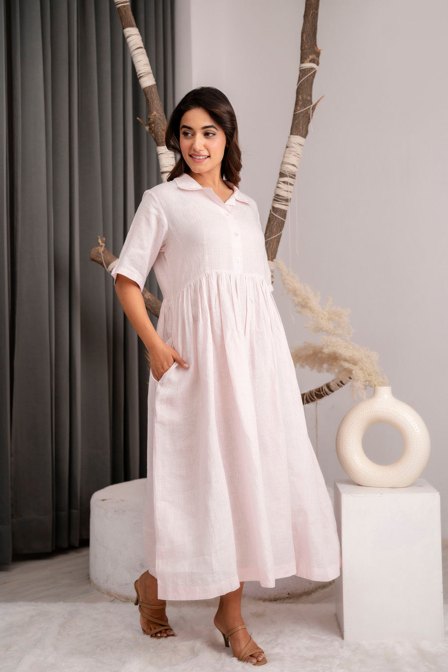 Classic Long Linen Dress: woman in Powder Pink dress, hand in pocket, side angle