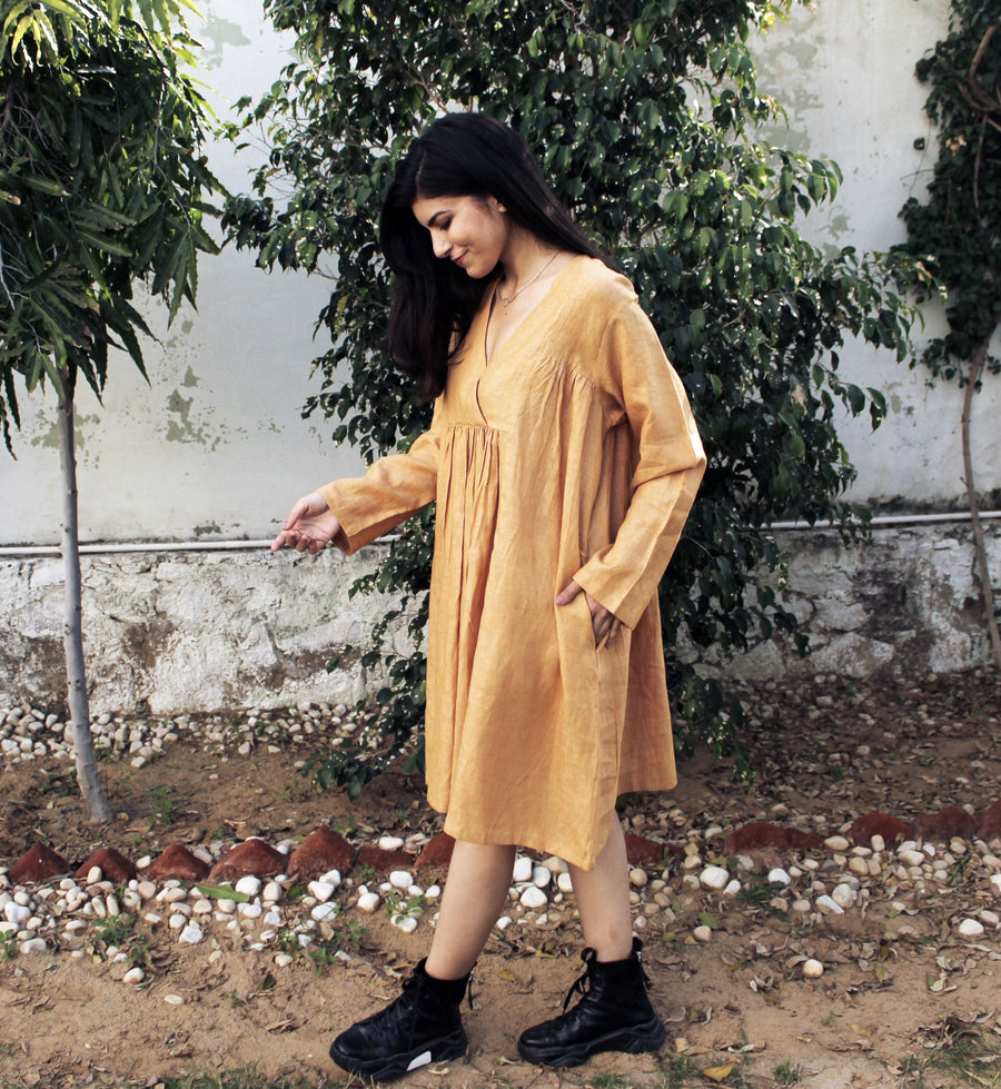 Cottagecore Linen Midi Dress: side view of woman in mustard linen midi dress with pocket, hand out