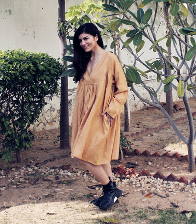 Cottagecore Linen Midi Dress: woman in mustard gathered linen midi dress, hand at her side, front view