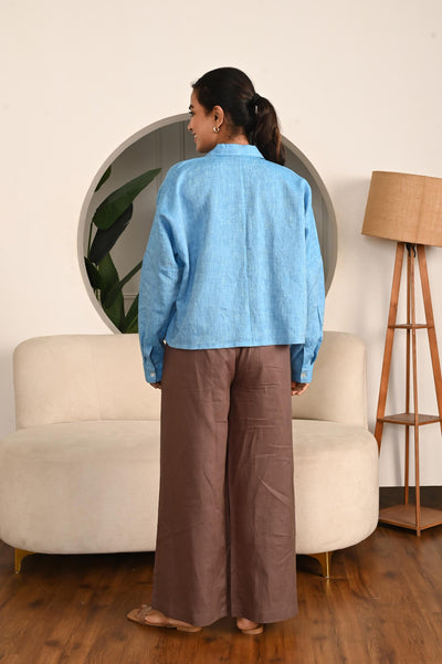Cropped Linen Shirt: back view of Sky Blue cropped linen shirt and brown trousers