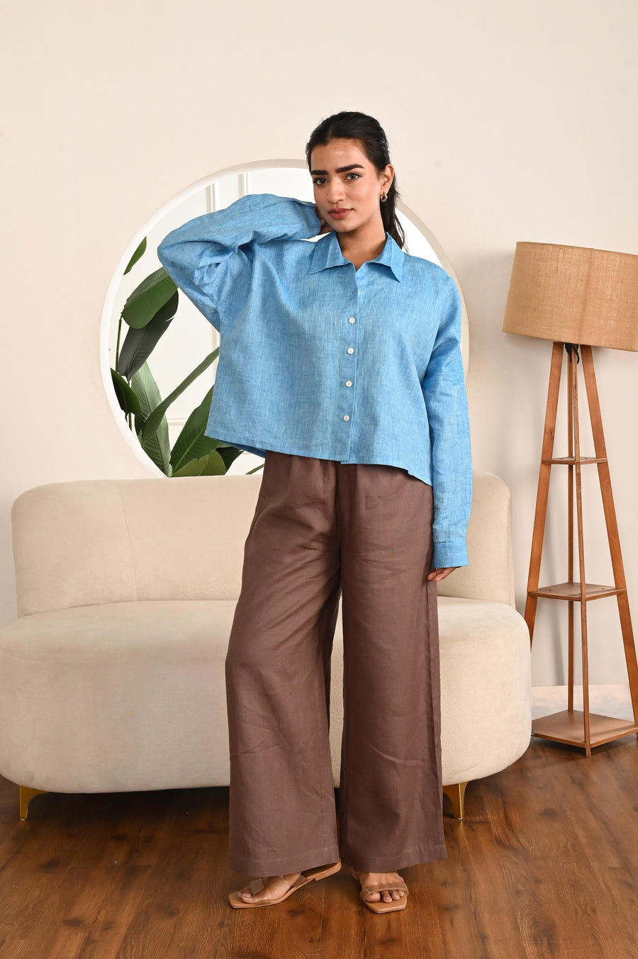 Cropped Linen Shirt: woman in Sky Blue cropped linen shirt with one hand on hip, brown trousers