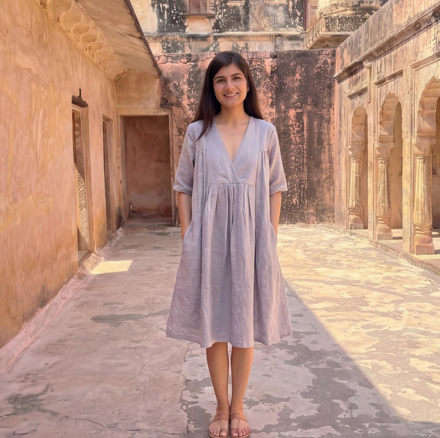 Flax Linen A-Line Empire Waist Dress: front view in Lavender dress standing in an arched corridor