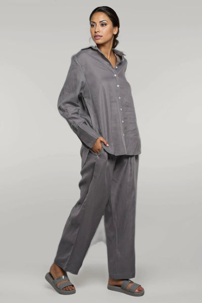 Grey Linen Co-ord Set, Shirt & Pants: Grey linen shirt and pants worn with dark sandals on a grey backdrop
