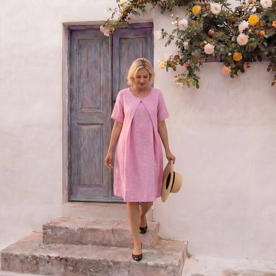 Layered Linen Knee-Length Dress: woman in pink layered linen dress carrying a straw hat, walking down steps
