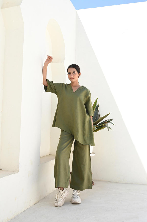 Linen Co-ord Set, Tunic Top & Palazzo Pants: woman in Moss Green tunic top and palazzo pants, hand on a white wall