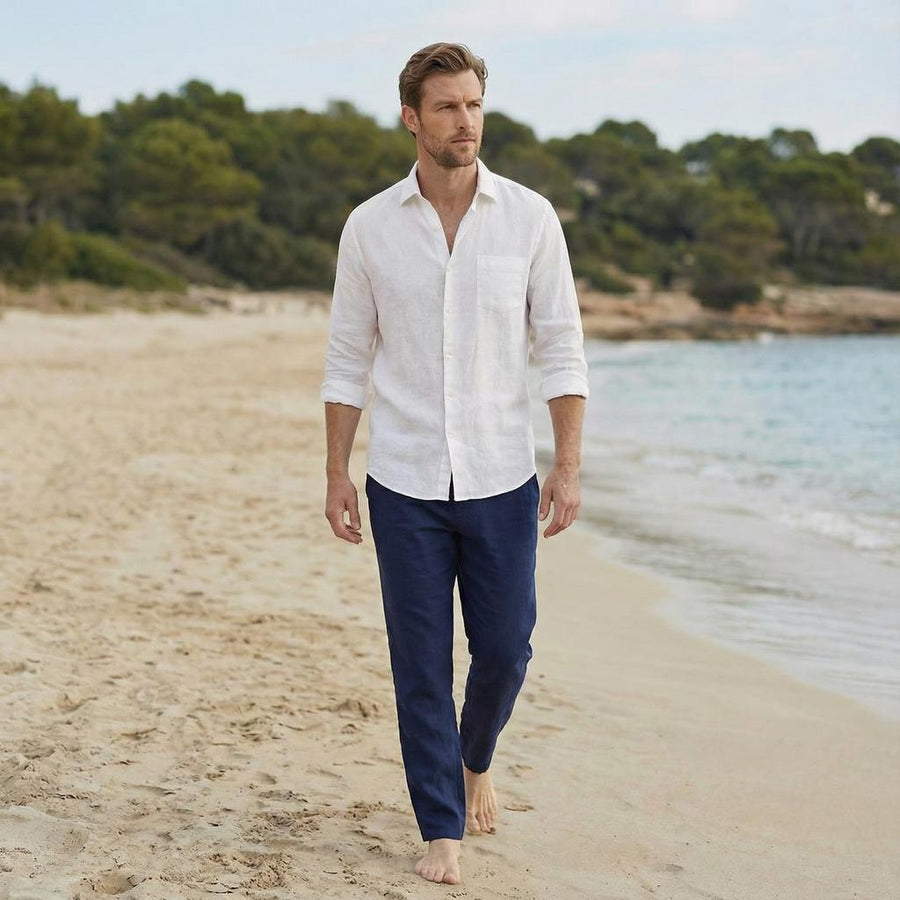 Men's Linen Button Up Shirt, Straight Collar: man walking on sand, arms at sides, white shirt and navy trousers