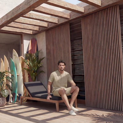 Men's Short Sleeve Linen Shirt, Resort Fit: man seated on the edge of a lounger in Beige shirt and shorts