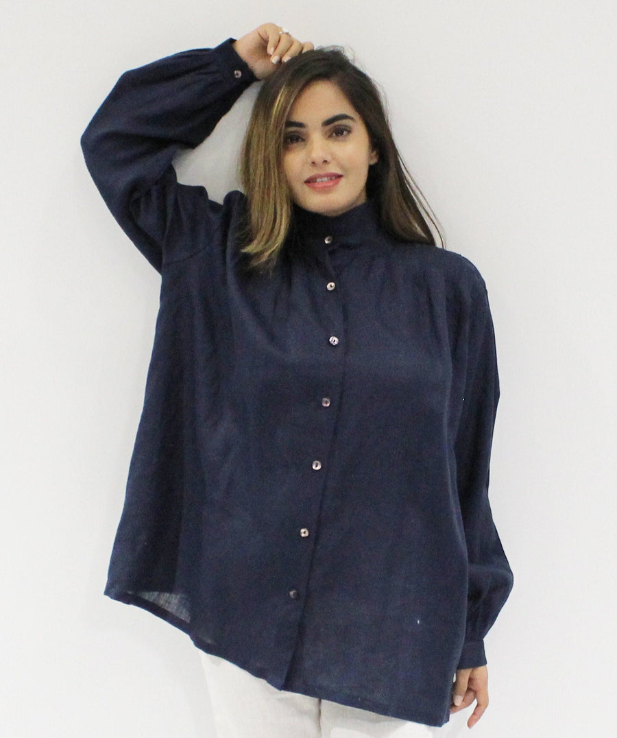 Oversized Blue Linen Shirt, Button-Up: woman in Navy Blue oversized linen shirt with hand raised to her hair