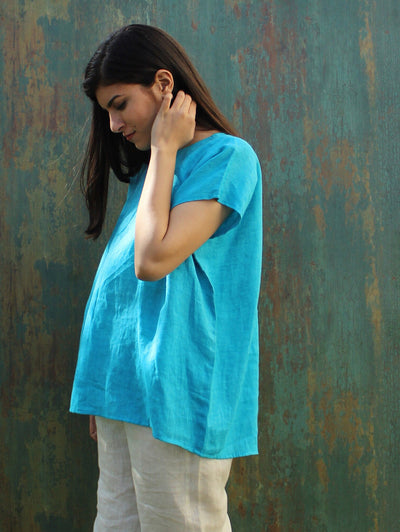 Oversized Square Linen Top: side view of woman in Turquoise Blue oversized linen top, hand at neck
