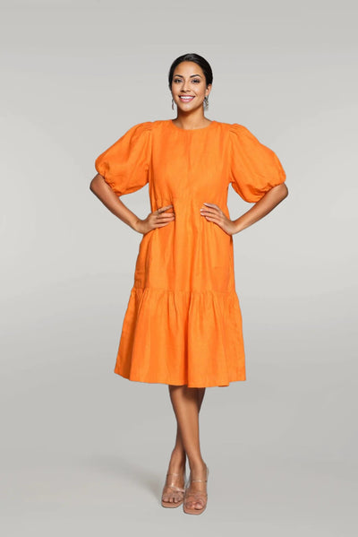Pure Linen Midi Tunic Dress: woman in orange linen midi tunic dress with puff sleeves and tiered hem, hands on hips