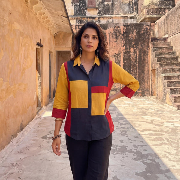 Red Blue Yellow Colorblock Linen Top: woman in mustard, navy and red colorblock shirt, hand on hip, alley