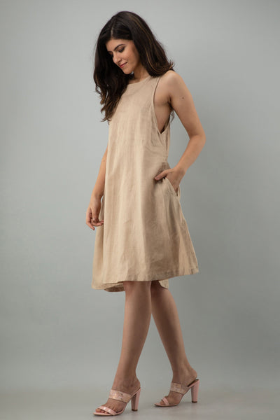 Sleeveless Linen Halter Midi Dress: woman in Latte sleeveless linen halter midi dress, side angle, hand in pocket