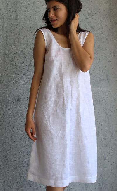 Sleeveless White Linen Tunic Dress: woman in white sleeveless linen tunic dress, hands at her hair, front view