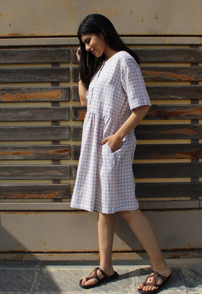 Smocked Linen Midi Dress, Short Sleeve: woman in gingham linen dress against wood slats, looking down, hand in pocket